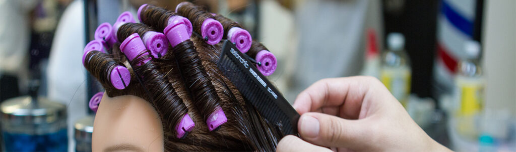 A cosmetologist practicing perms