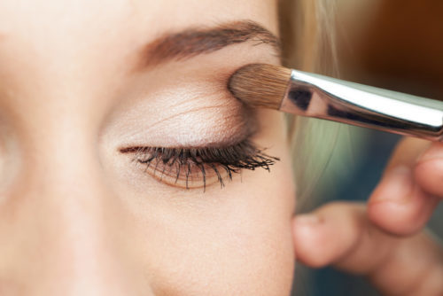 professional makeup artist applying eye shadow