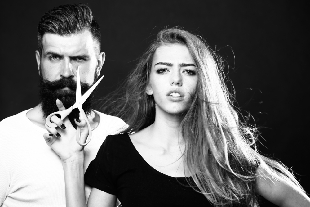 woman with a pair of scissors posing with a man in high fashion