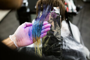 hair painter coloring a client's hair in a rainbow