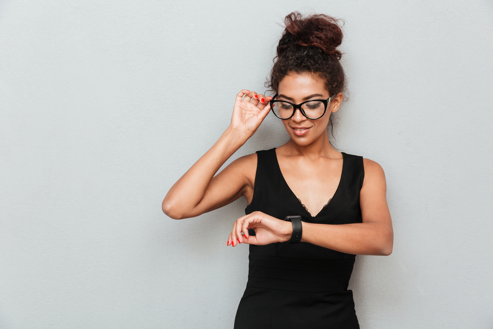 Woman with glasses looking at her watch.